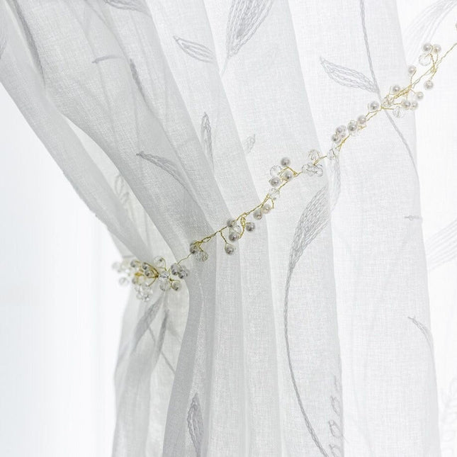 Gjennomsiktig gardin med broderte grener