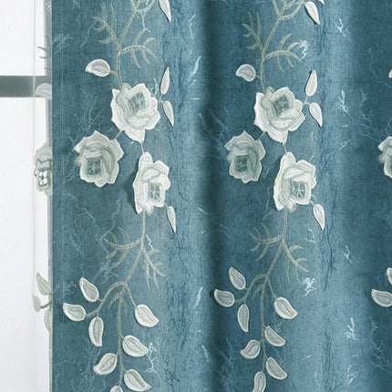 Blå gardin med hvite broderte blomster