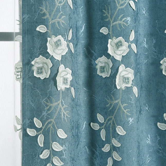 Blå gardin med hvite broderte blomster