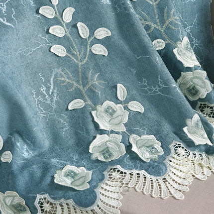 Blå gardin med hvite broderte blomster