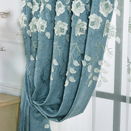 Blå gardin med hvite broderte blomster