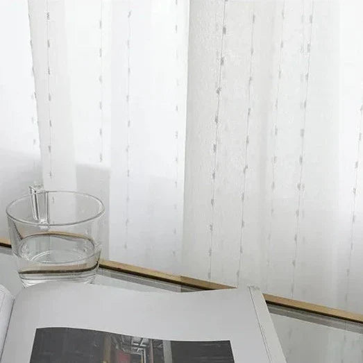 Hvit tynn gardin med diskret broderi