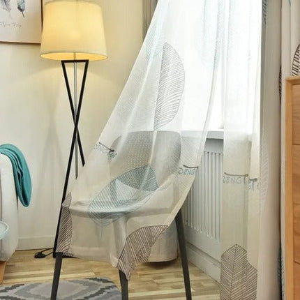 Florlett gardin med grått bladmotiv