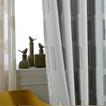 Grå lystett gardin med geometrisk mønster