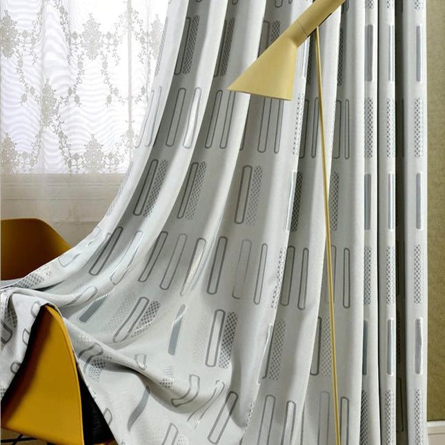 Grå lystett gardin med geometrisk mønster